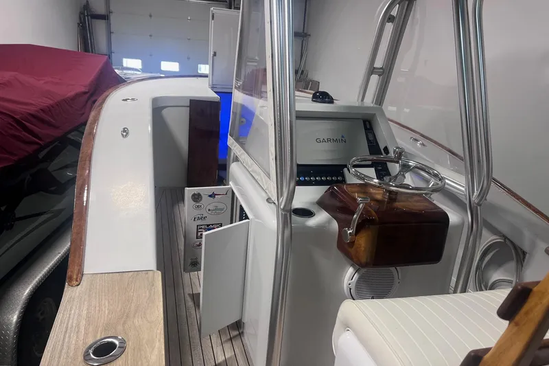Slide: The Image of 2017 Harrison Boatworks 28 Center Console with Garmin navigation system in a garage setting. - 17