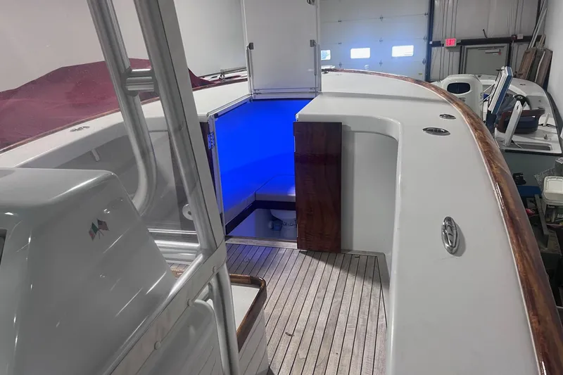 Slide: The Image of 2017 Harrison Boatworks 28 Center Console with blue interior lighting in a garage. - 19