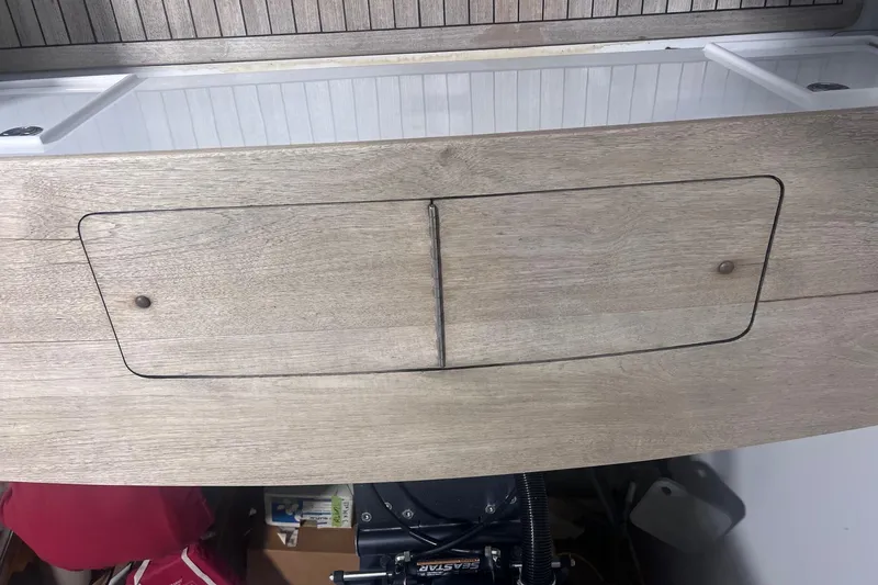 Slide: The Image of 2017 Harrison Boatworks 28 Center Console, wooden panel detail with storage compartment. - 22