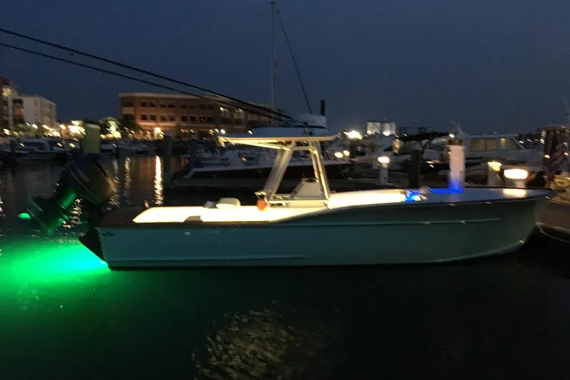 Slide: The Image of 2017 Harrison Boatworks 28 Center Console illuminated at night in a marina. - 4