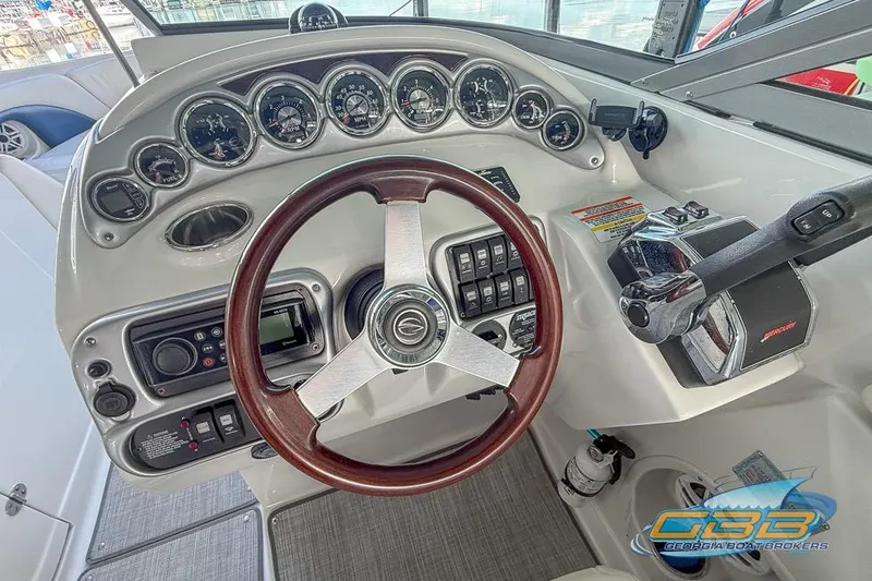Slide: The Image of 2009 Crownline 300 LS boat dashboard with gauges, steering wheel, and controls. - 2