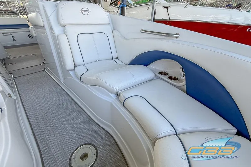 Slide: The Image of 2009 Crownline 300 LS boat interior with white and blue seating, cup holders, and carpeted flooring. - 20