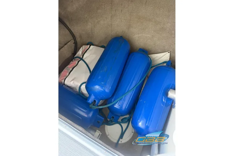 Slide: The Image of Storage compartment with blue fenders in a 2009 Crownline 300 LS boat. - 33
