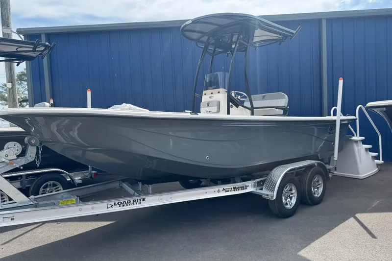 The Image of 2026 Carolina Skiff 21 LS boat on trailer, parked near blue building. - 0