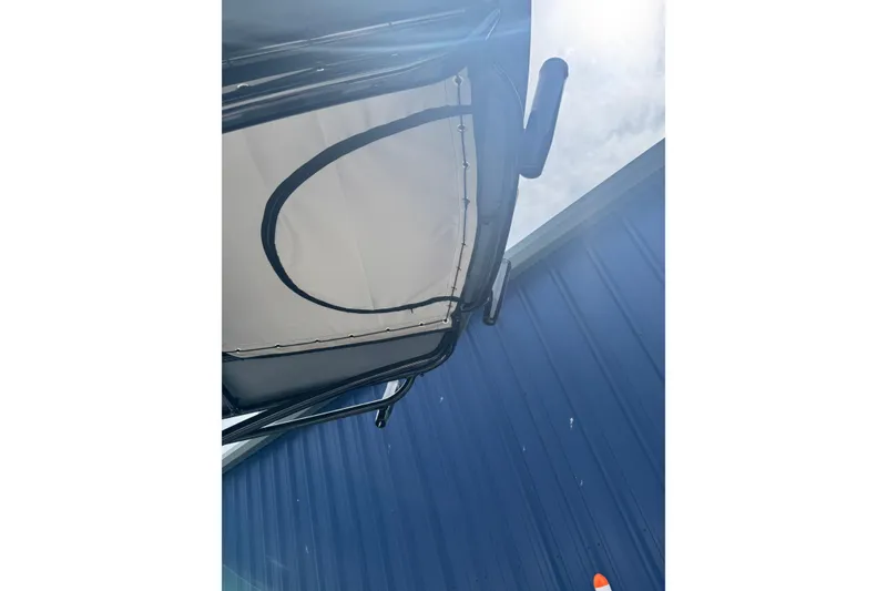 Slide: The Image of 2026 Carolina Skiff 21 LS boat canopy against blue sky and building. - 6