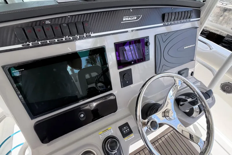Slide: The Image of Control panel of a 2017 Boston Whaler 350 Outrage boat with steering wheel and navigation screens. - 11