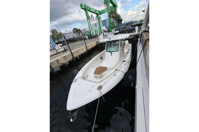 Slide: The Image of 2017 Boston Whaler 350 Outrage docked at marina, showcasing sleek design and spacious deck. - 5
