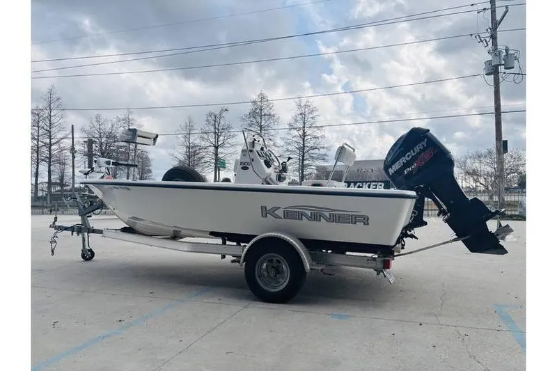 Slide: The Image of 2008 Kenner Vision 1800 boat on trailer with Mercury outboard motor, parked outdoors. - 13