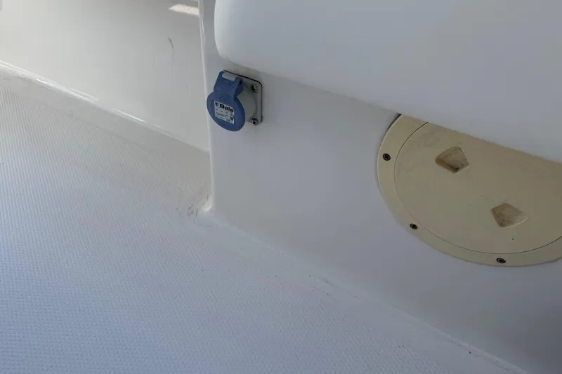 Slide: The Image of 2023 Robalo 246 Cayman SD boat deck with utility access panel and outlet. - 10