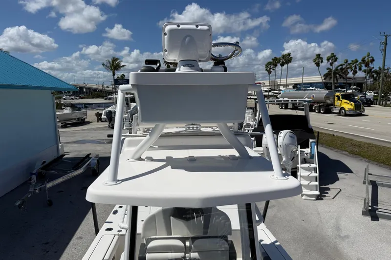 Slide: The Image of 2023 Robalo 246 Cayman SD boat with radar, parked outdoors under a blue sky. - 13