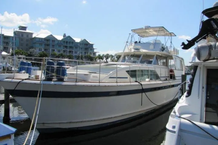The Image of 1973 Chris Craft Commander 55 yacht docked at marina with waterfront buildings. - 0