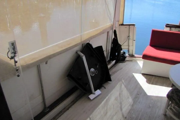 Slide: The Image of 1973 Chris-Craft 55 Commander yacht deck with red seating and lake view. - 10