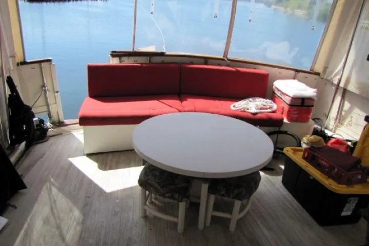 Slide: The Image of 1973 Chris-Craft 55 Commander interior with red seating, round table, and lake view. - 11