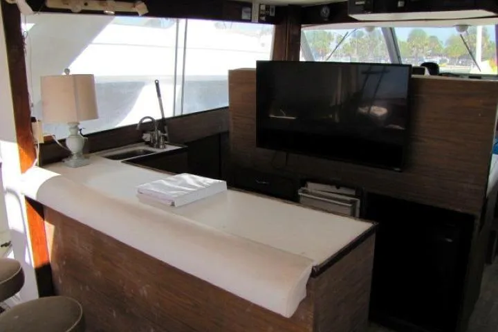 Slide: The Image of 1973 Chris-Craft 55 Commander interior with bar, sink, and mounted TV. - 13