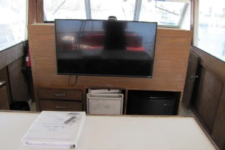 Slide: The Image of 1973 Chris-Craft 55 Commander interior with TV, drawers, and mini fridge. - 14