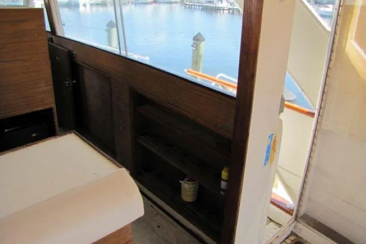 Slide: The Image of Interior view of 1973 Chris-Craft 55 Commander yacht with wooden paneling and waterfront backdrop. - 15
