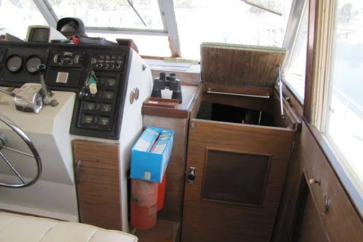 Slide: The Image of 1973 Chris-Craft 55 Commander helm with vintage controls and storage compartments. - 18