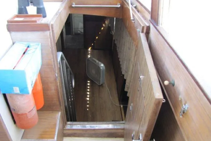Slide: The Image of Interior view of 1973 Chris-Craft 55 Commander yacht, featuring wooden stairs and a fan. - 19