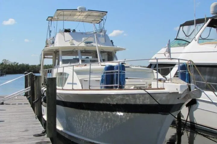 Slide: The Image of 1973 Chris-Craft 55 Commander yacht docked at marina under clear blue sky. - 2