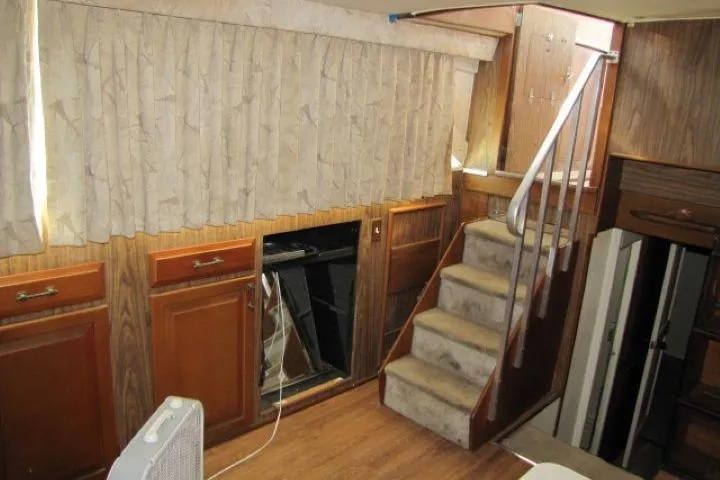 Slide: The Image of Interior of a 1973 Chris-Craft 55 Commander with wooden cabinets and carpeted stairs. - 20