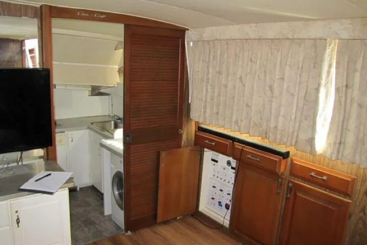 Slide: The Image of Interior of a 1973 Chris-Craft 55 Commander yacht with wooden cabinets and appliances. - 21