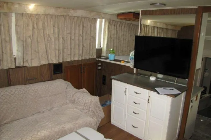 Slide: The Image of Interior of a 1973 Chris-Craft 55 Commander yacht with cozy seating and modern amenities. - 25
