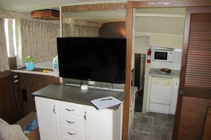 Slide: The Image of Interior of a 1973 Chris-Craft 55 Commander yacht with TV, cabinets, and kitchenette. - 26