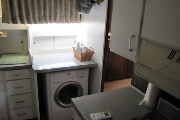 Slide: The Image of Laundry area inside 1973 Chris-Craft 55 Commander yacht with washer and storage cabinets. - 27
