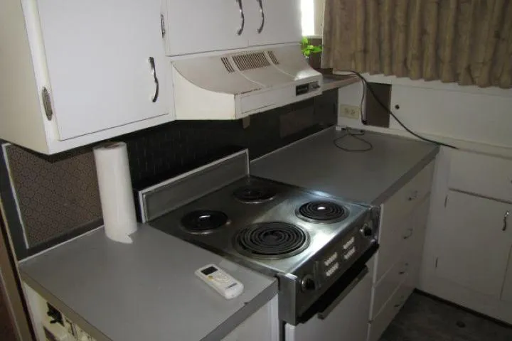 Slide: The Image of 1973 Chris-Craft 55 Commander kitchen with electric stove, white cabinets, and countertop. - 30