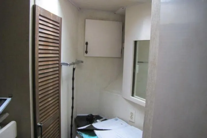 Slide: The Image of Interior of 1973 Chris-Craft 55 Commander with wooden cabinet and cluttered desk. - 34