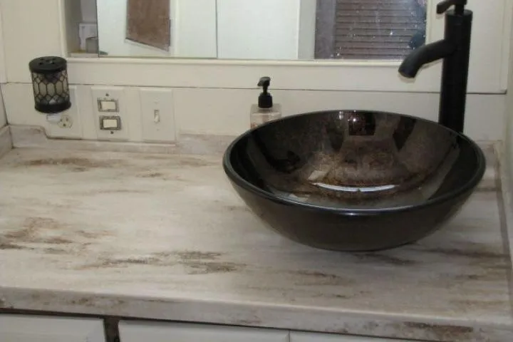 Slide: The Image of Marble countertop with vessel sink and black faucet on a 1973 Chris-Craft 55 Commander. - 44