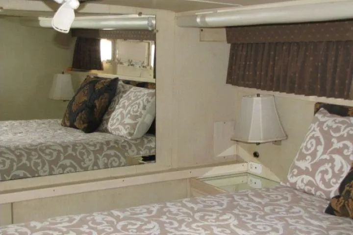 Slide: The Image of Interior of 1973 Chris-Craft 55 Commander yacht with patterned bedding and mirrored wall. - 45