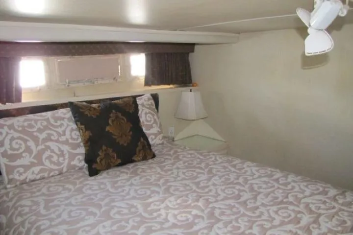 Slide: The Image of Cozy bedroom interior of 1973 Chris-Craft 55 Commander yacht with patterned bedding. - 47