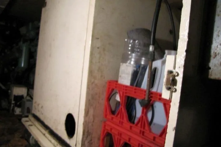 Slide: The Image of Storage compartment on a 1973 Chris-Craft 55 Commander boat with red crates and equipment. - 55