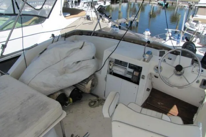 Slide: The Image of 1973 Chris-Craft 55 Commander boat cockpit with steering wheel and marina view. - 6