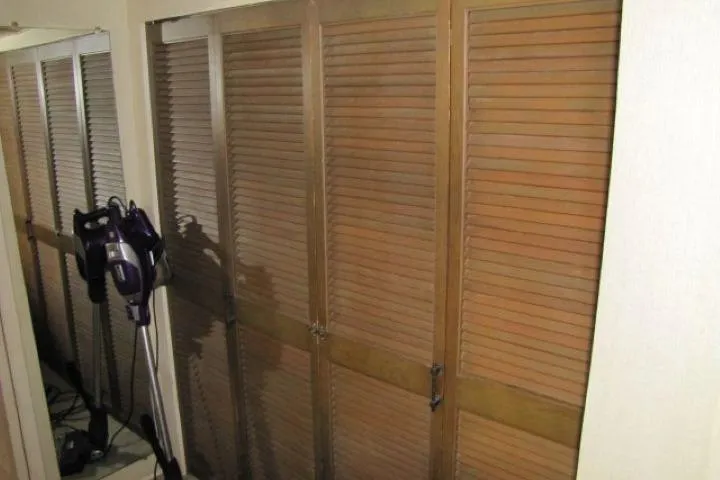 Slide: The Image of Wooden louvered closet doors with a vacuum cleaner nearby, inside a 1973 Chris-Craft 55 Commander. - 60