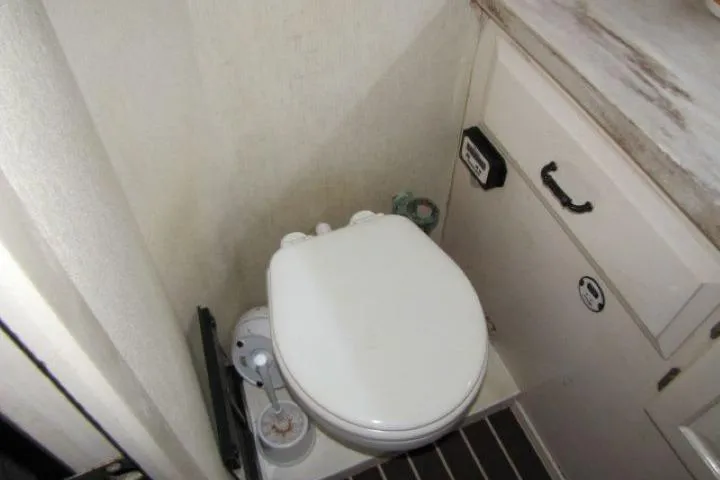 Slide: The Image of 1973 Chris-Craft 55 Commander bathroom with compact toilet and storage cabinet. - 62