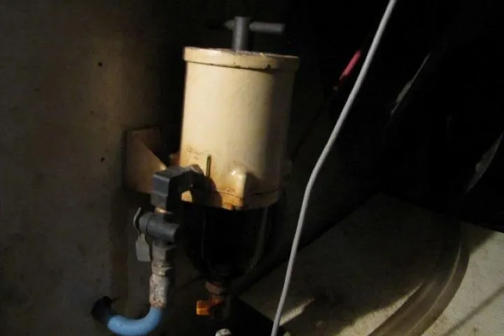 Slide: The Image of 1973 Chris-Craft 55 Commander engine component, featuring a cylindrical filter with attached hoses. - 70