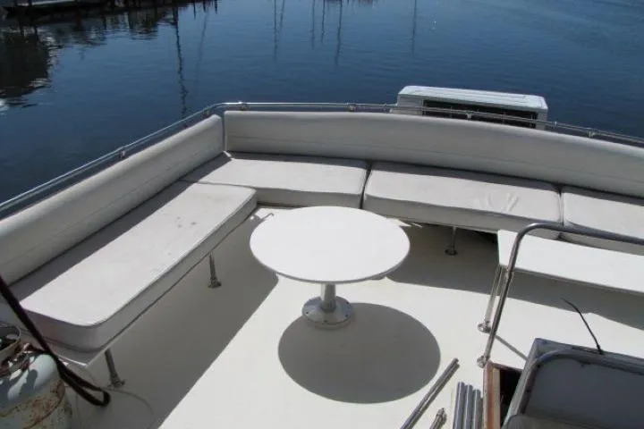 Slide: The Image of 1973 Chris-Craft 55 Commander yacht deck with white seating and round table. - 8