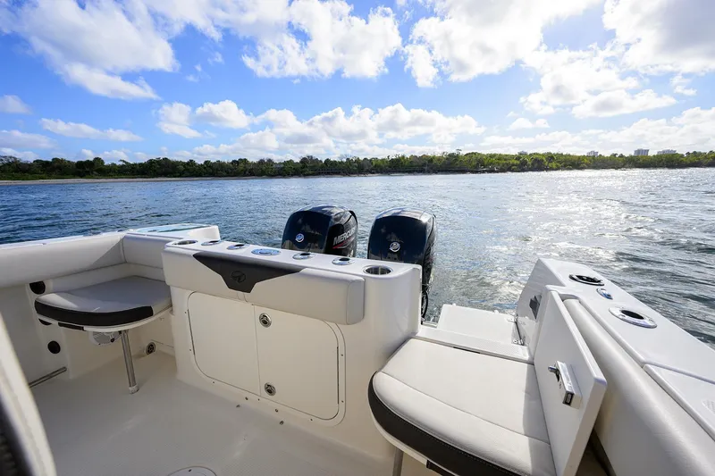 Slide: The Image of 2022 Sailfish 242 CC boat interior with dual engines on a sunny day. - 10