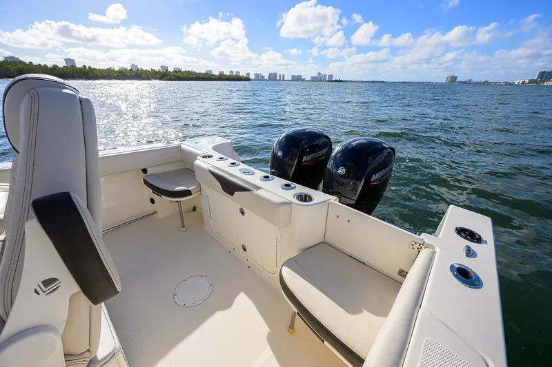 Slide: The Image of 2022 Sailfish 242 CC boat interior with dual Mercury engines on a sunny day. - 11