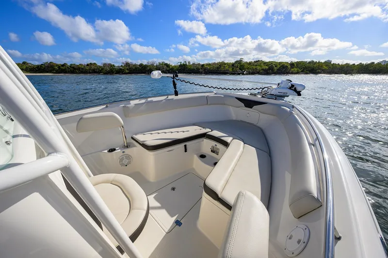 Slide: The Image of 2022 Sailfish 242 CC boat interior with seating, on a sunny day by the water. - 12