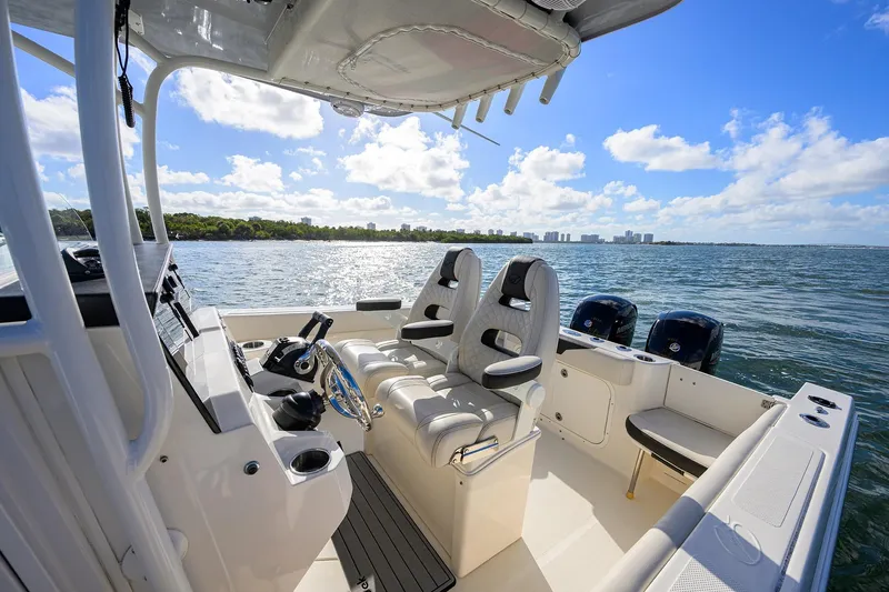 Slide: The Image of 2022 Sailfish 242 CC boat interior with dual seats, ocean view, and clear sky. - 14