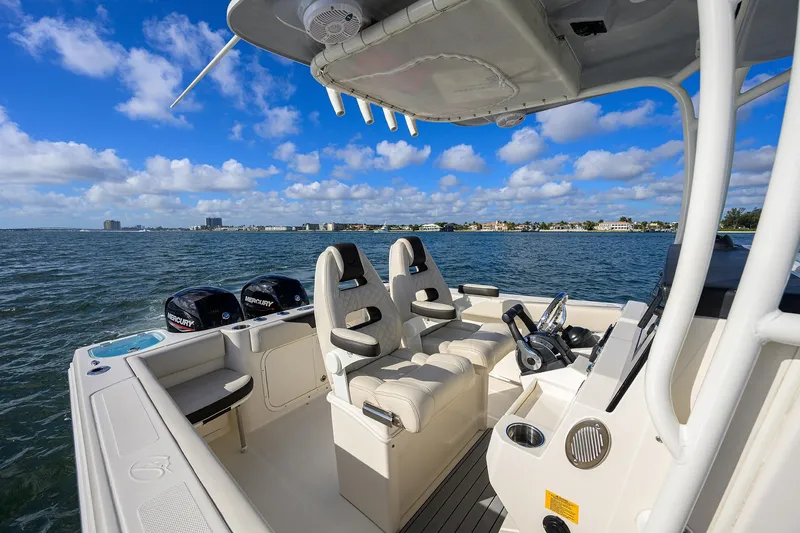 Slide: The Image of 2022 Sailfish 242 CC boat interior with dual Mercury engines on open water. - 16
