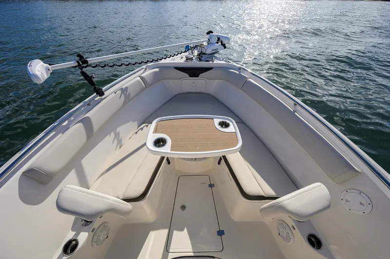 Slide: The Image of 2022 Sailfish 242 CC boat interior with seating and table on calm water. - 18