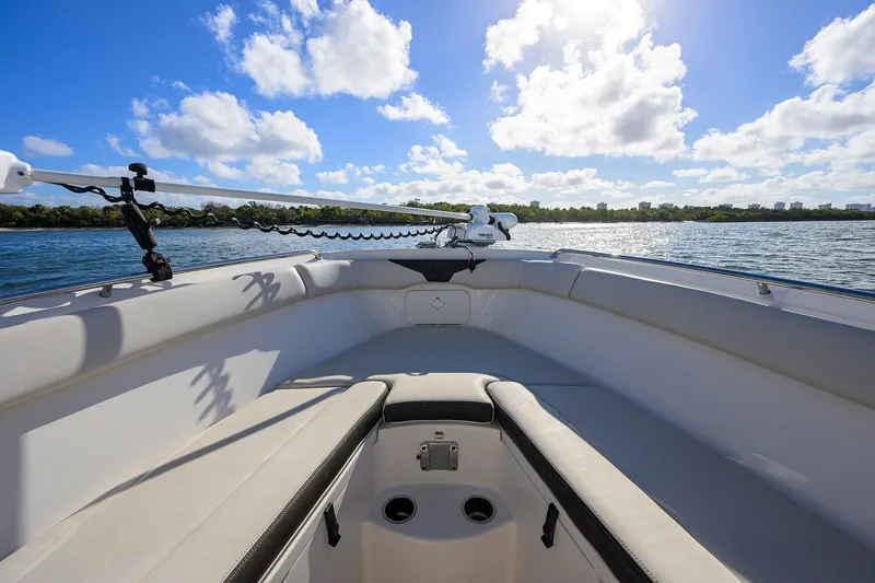 Slide: The Image of 2022 Sailfish 242 CC boat interior with seating, under a bright blue sky. - 6