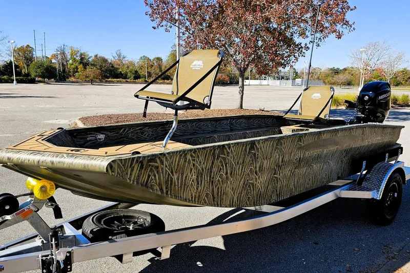 Slide: The Image of 2026 Tracker Grizzly 1650 T Prairie Wings Edition boat on trailer, camo design, outdoor setting. - 6