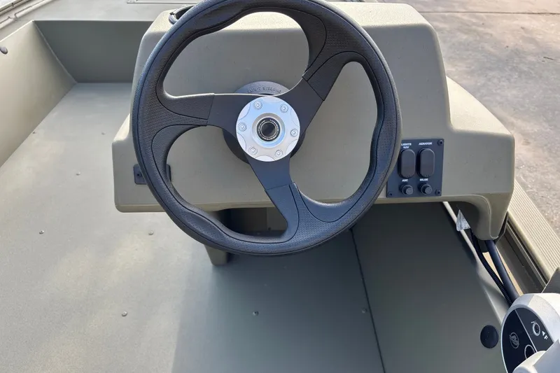 Slide: The Image of Steering console of 2026 Tracker Grizzly 1648 SC boat, featuring control switches. - 16