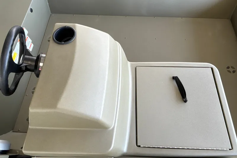Slide: The Image of 2026 Tracker Grizzly 1648 SC boat console with steering wheel and storage compartment. - 20