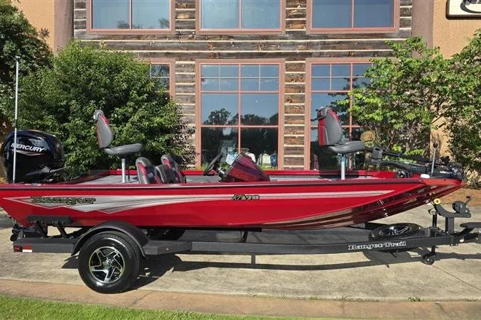 The Image of 2026 Ranger RT178 red fishing boat on trailer, parked outdoors near building. - 0
